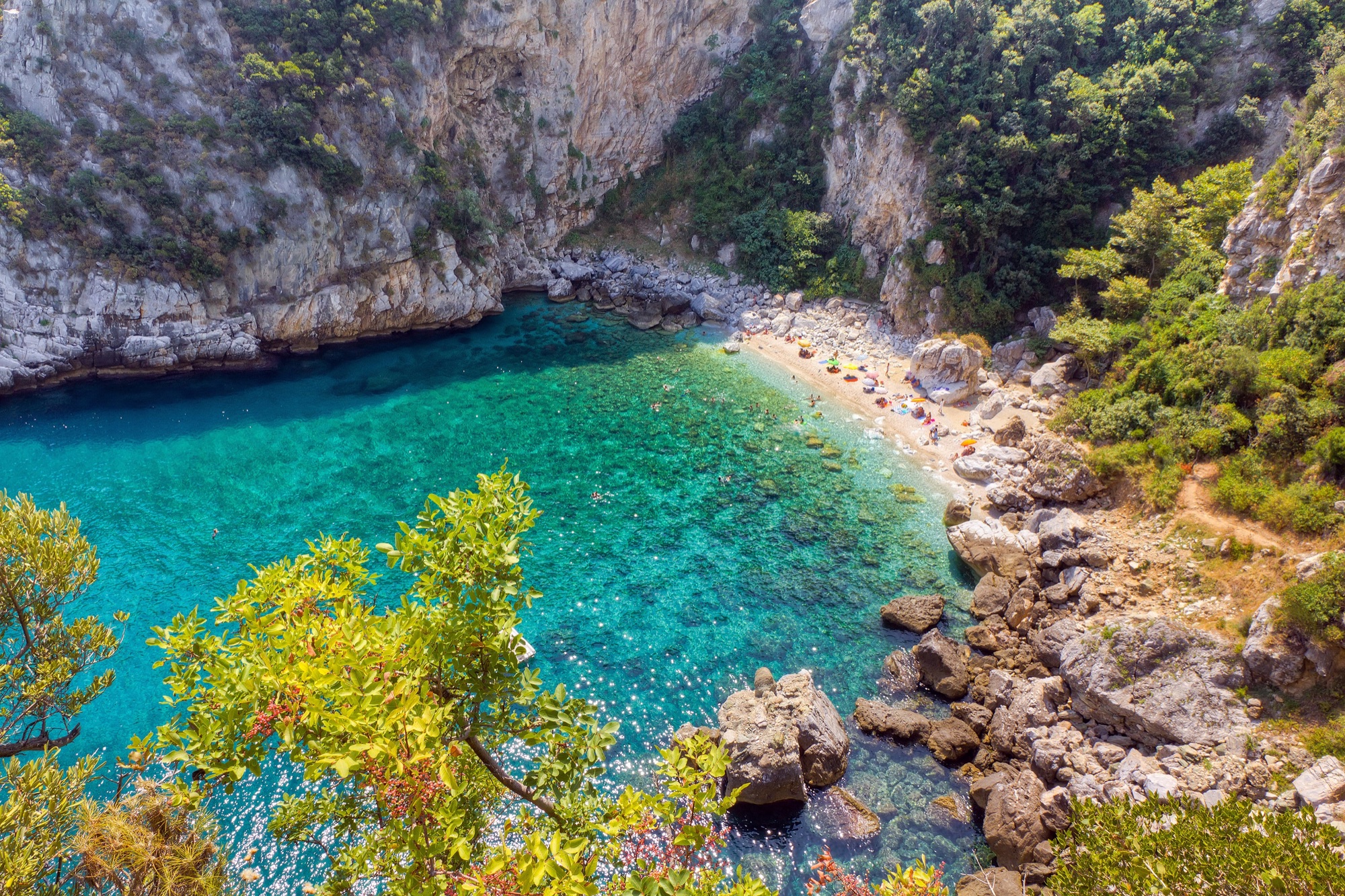 Turquoise waters of Fakistra beach framed by cliffs and greenery in Pelion, Greece