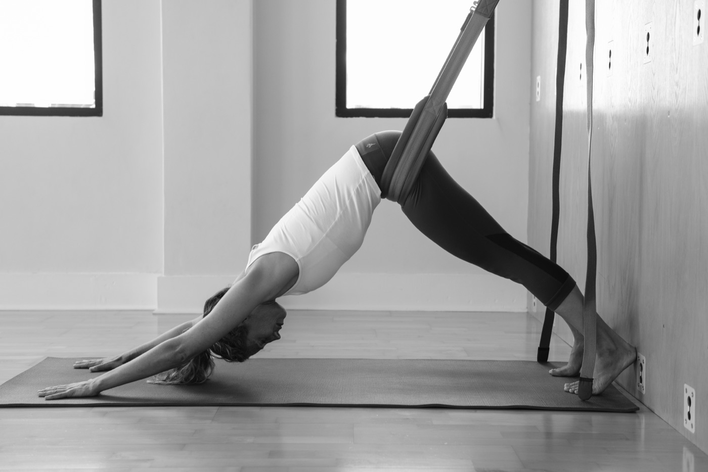 Alignment-based yoga practice using a wall rope in Downward Dog