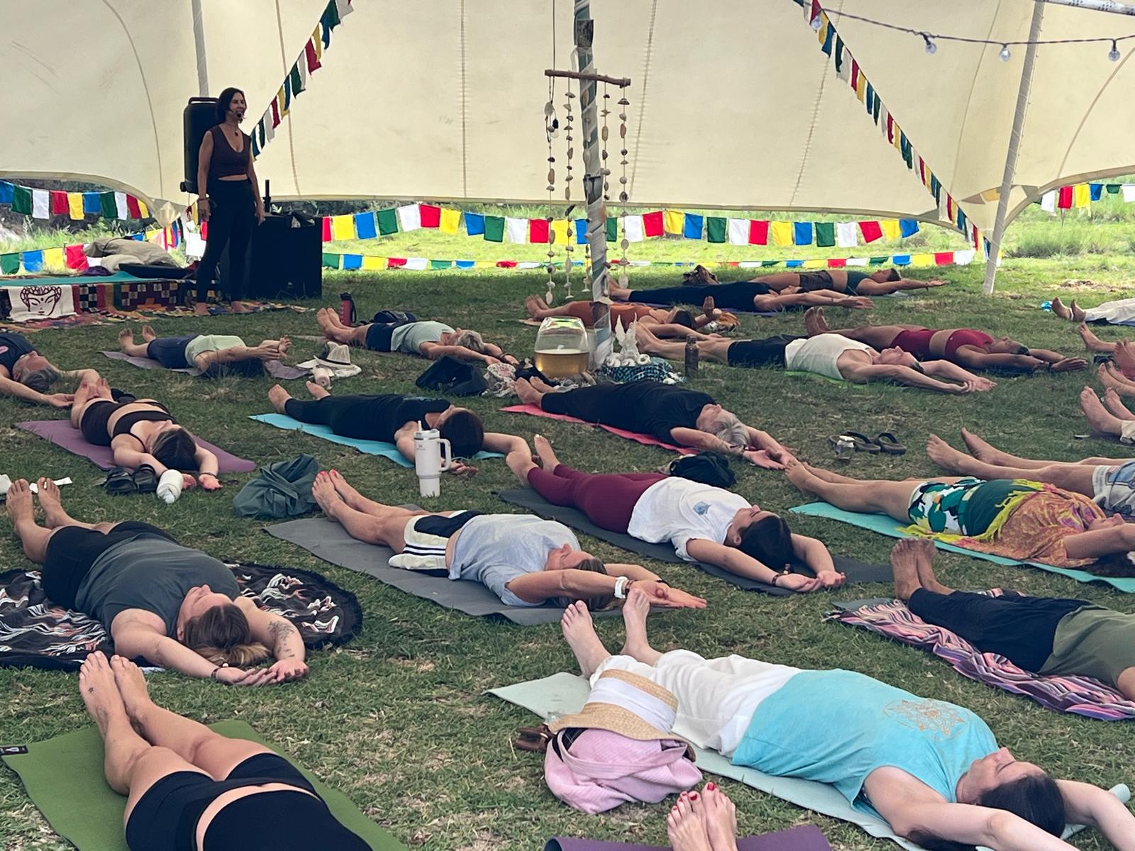 Amanda Lamprecht guiding Shavasana under the festival tent at SpiritFest