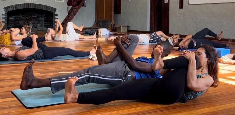Partner-supported supine leg stretches during workshop