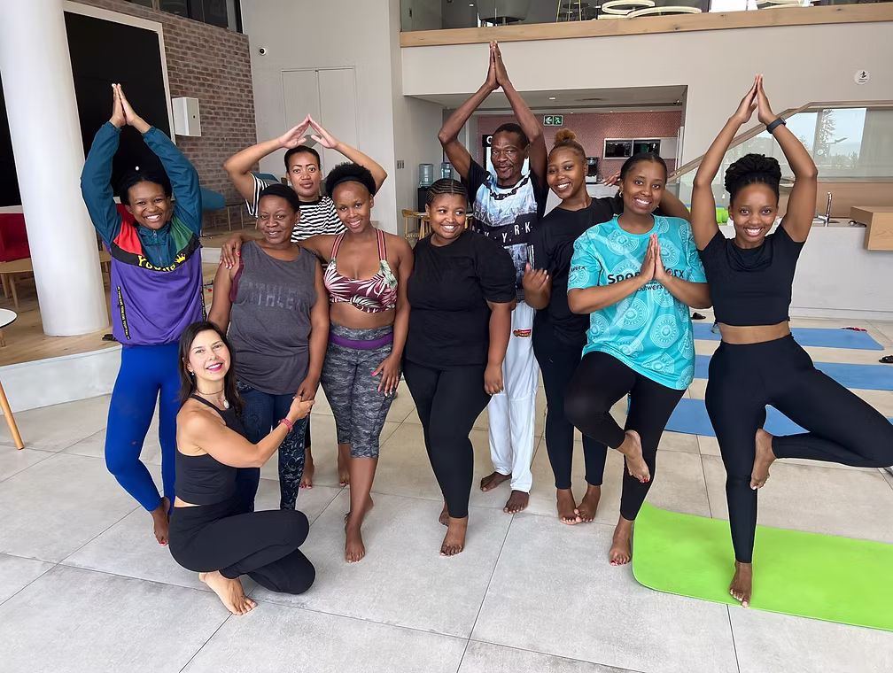 Students learning yoga teaching techniques and alignment