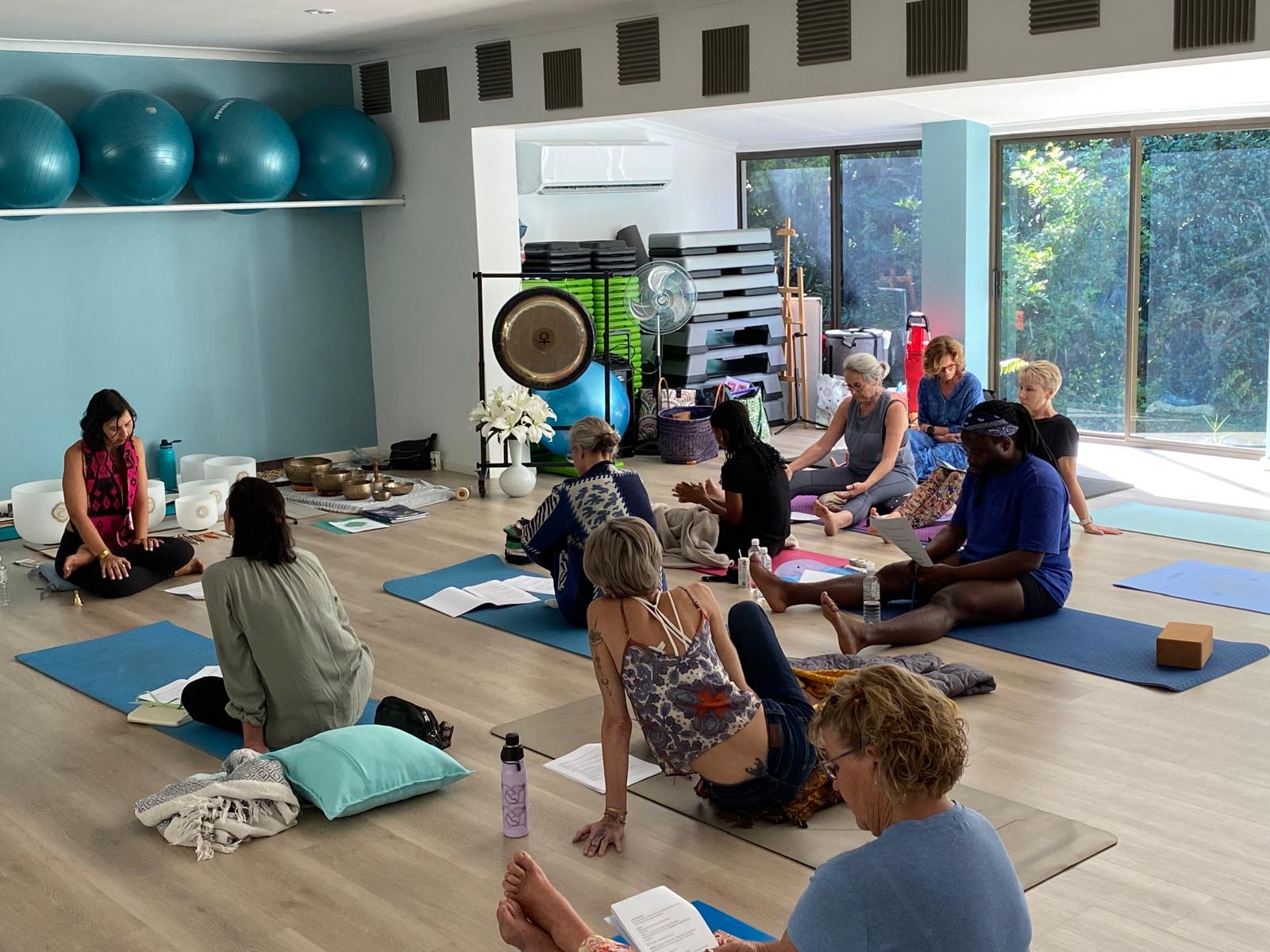 Sound healing circle with crystal singing bowls during yoga teacher training